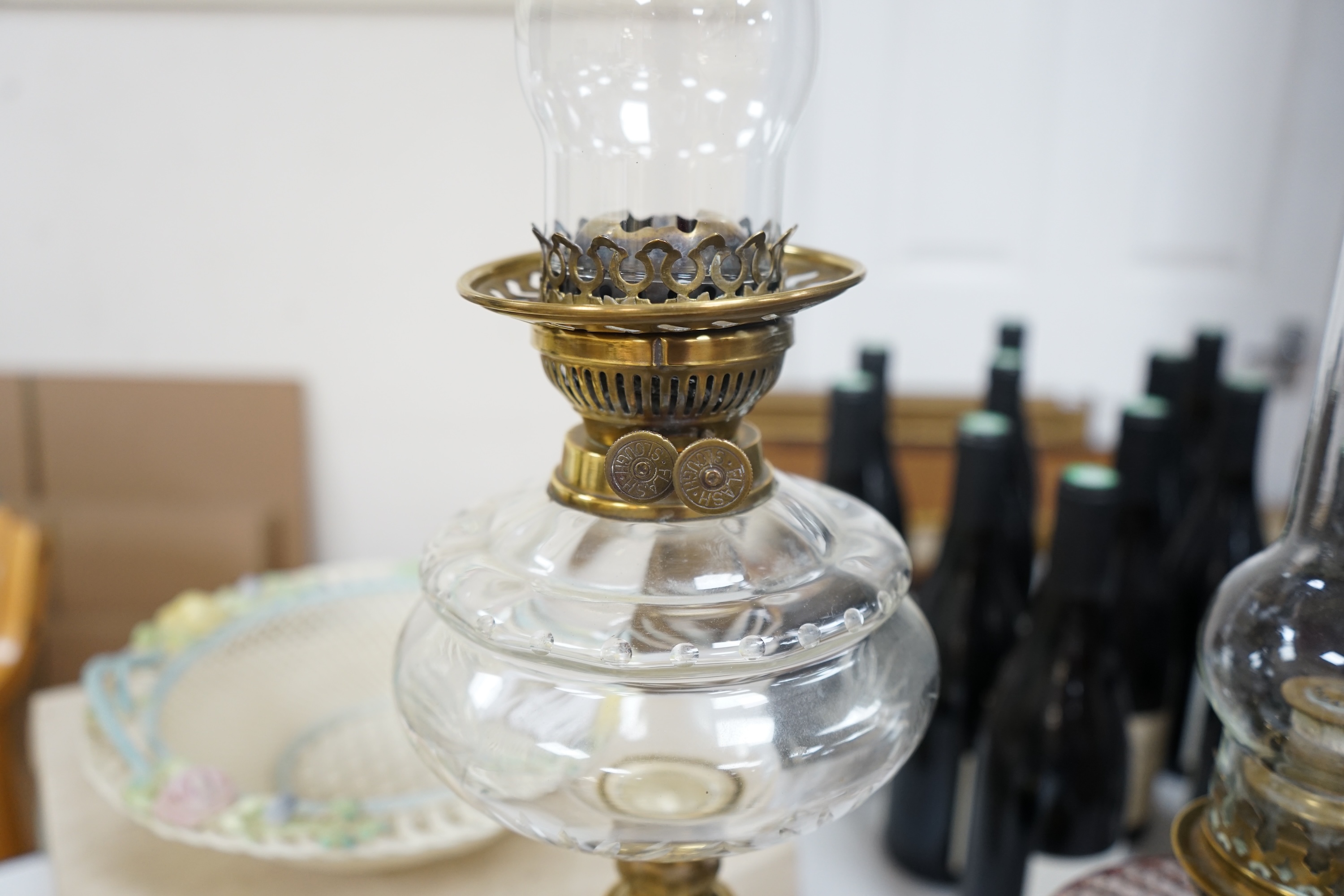 Two brass oil lamps with glass spirit tanks, tallest 67cm. Condition - good.